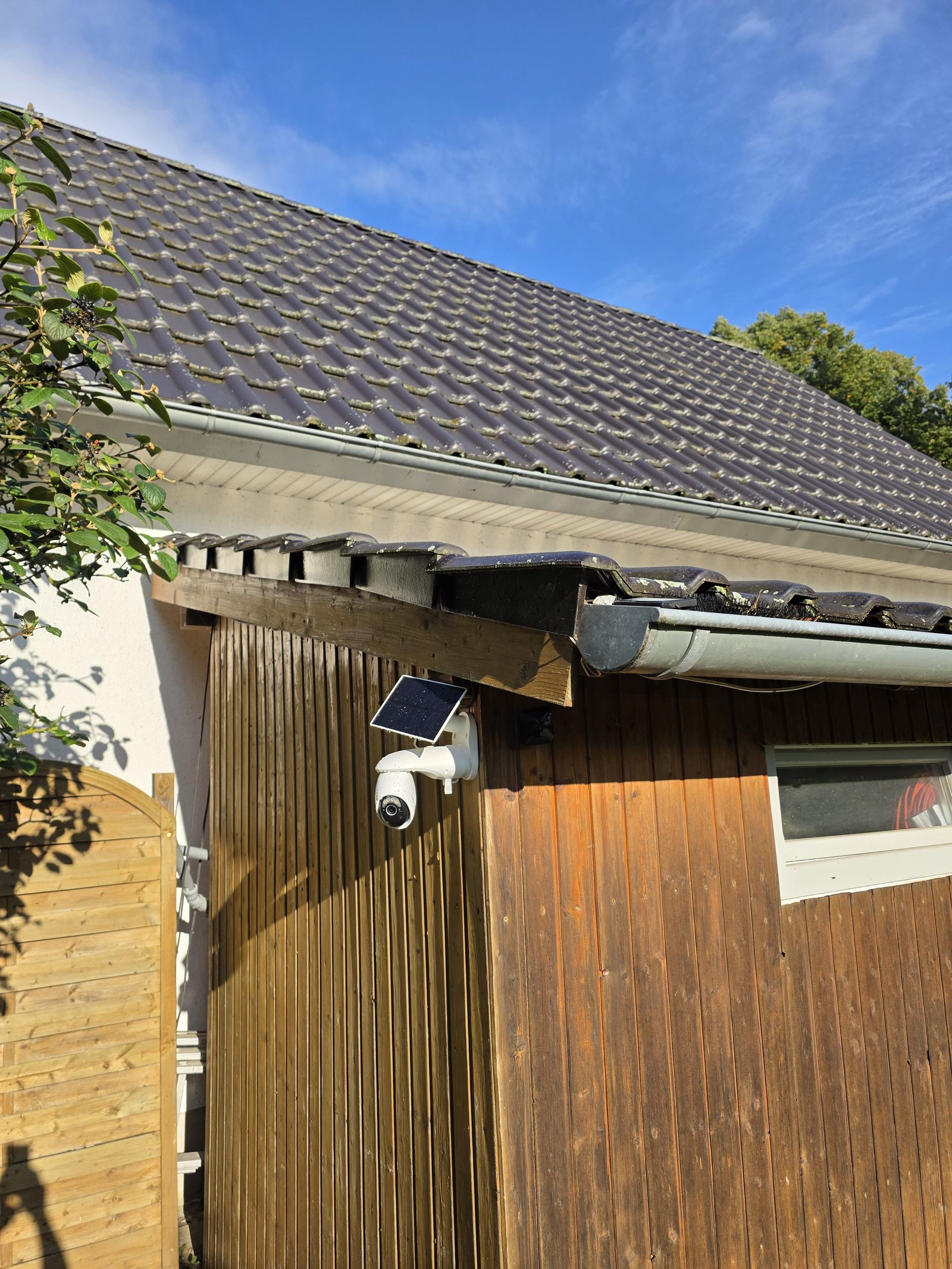 Tapo C660 KIT mit Solarpanel an der Holzfassade der Gartenhütte montiert